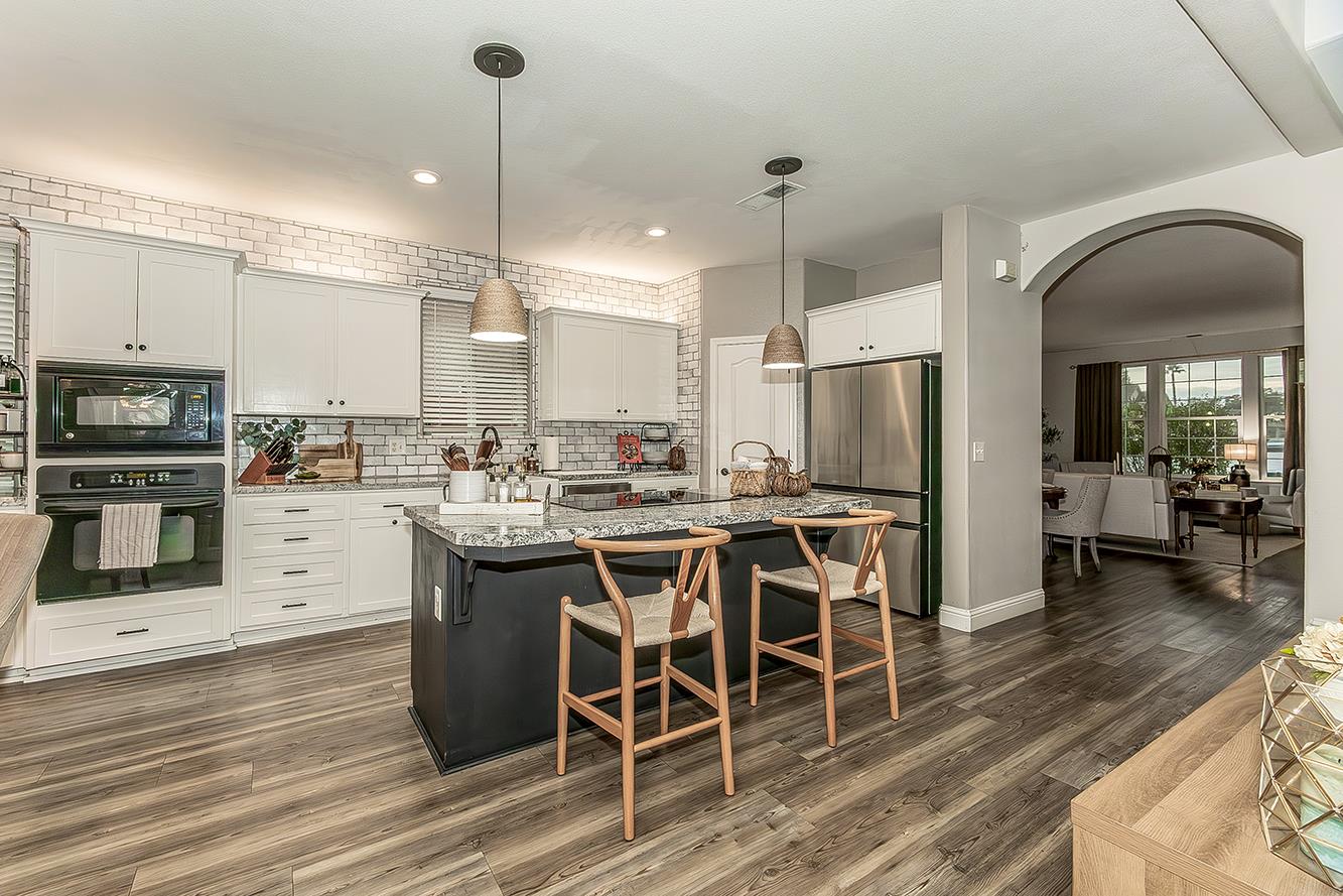 1175 Applegate Avenue Clovis, CA 93611 - Photo 8 of 65 a kitchen with stainless steel appliances kitchen island granite countertop a table chairs and a sink