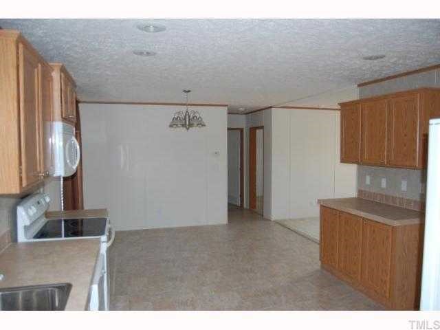3514 Walters Road Creedmoor, NC 27522 - Photo 5 of 9 a kitchen with cabinets and refrigerator