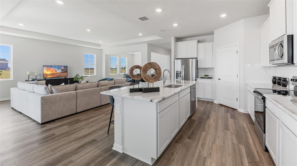 17932 Gander Terrace Lakewood Ranch, FL 34211 - Photo 7 of 52 a kitchen with stainless steel appliances kitchen island granite countertop a stove a sink and a refrigerator