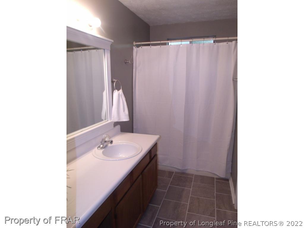 414 Saddle Ridge Road Fayetteville, NC 28311 - Photo 27 of 36 a bathroom with a sink a shower and a mirror