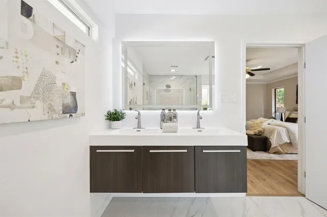 a en suite bathroom with a granite countertop sink and a mirror