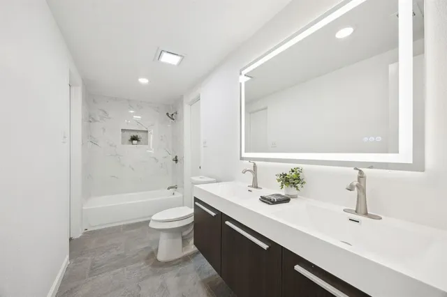 a bathroom with a double vanity sink toilet and shower