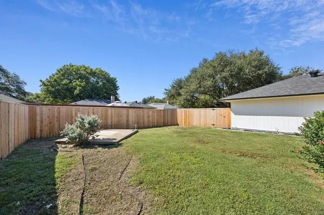 a view of a house with backyard and a tree