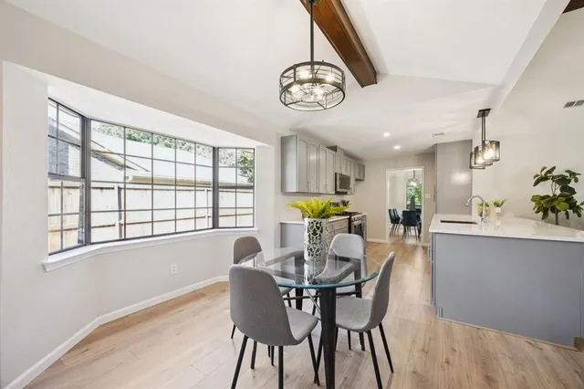 a view of a dining room with furniture a chandelier and wooden floor