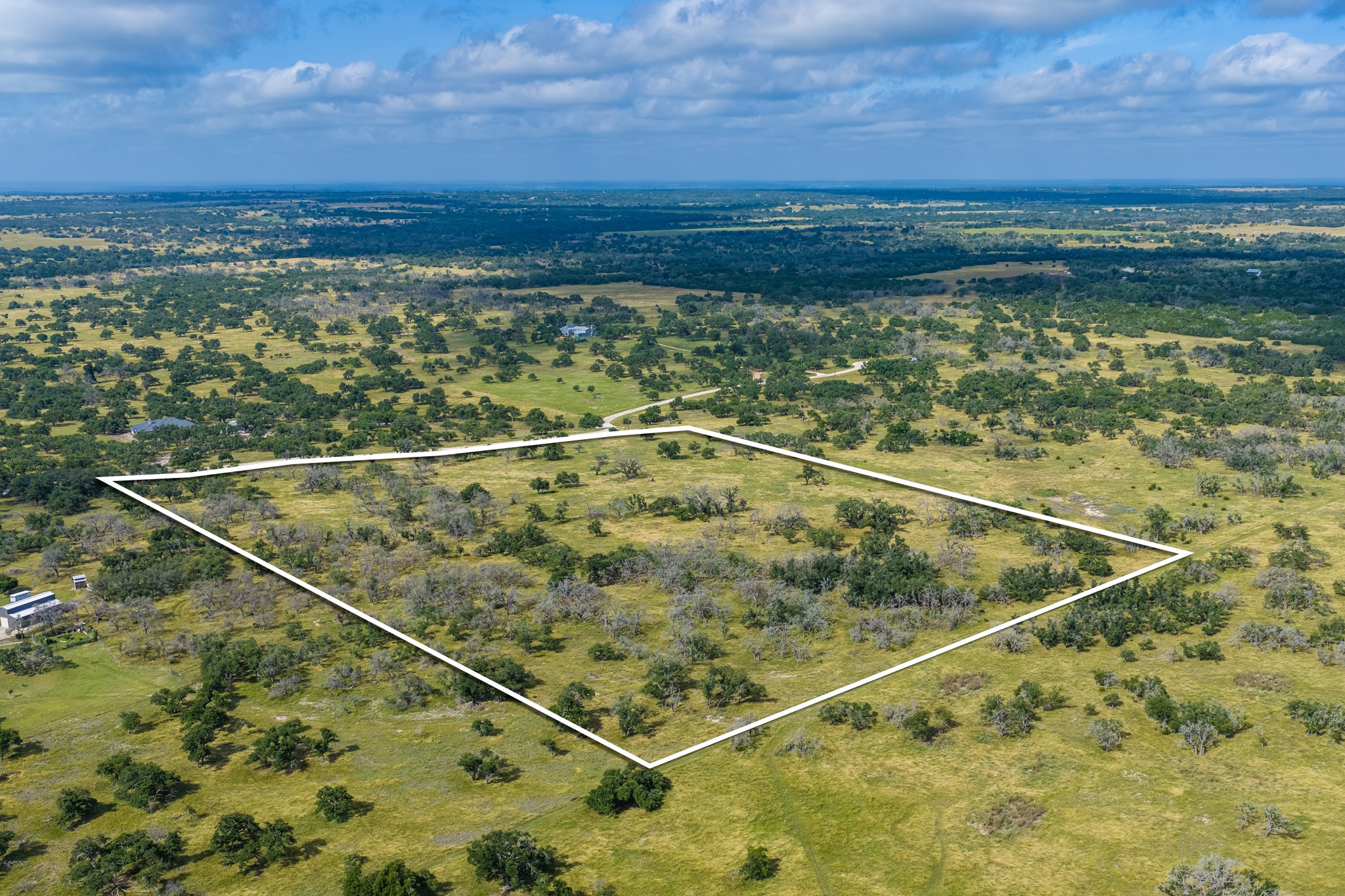 436 Stevens Ranch Road Harper, TX 78631 - Photo 30 of 31 Vast acreage outlines a prime building site surrounded by mature trees under expansive skies.