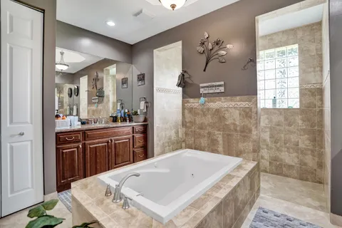 a bathroom with a tub a sink and mirror