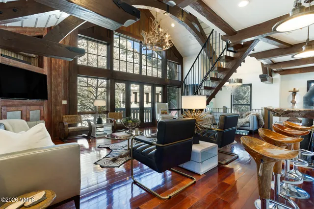 a view of a kitchen with stainless steel appliances kitchen island granite countertop a table chairs and a wooden floor