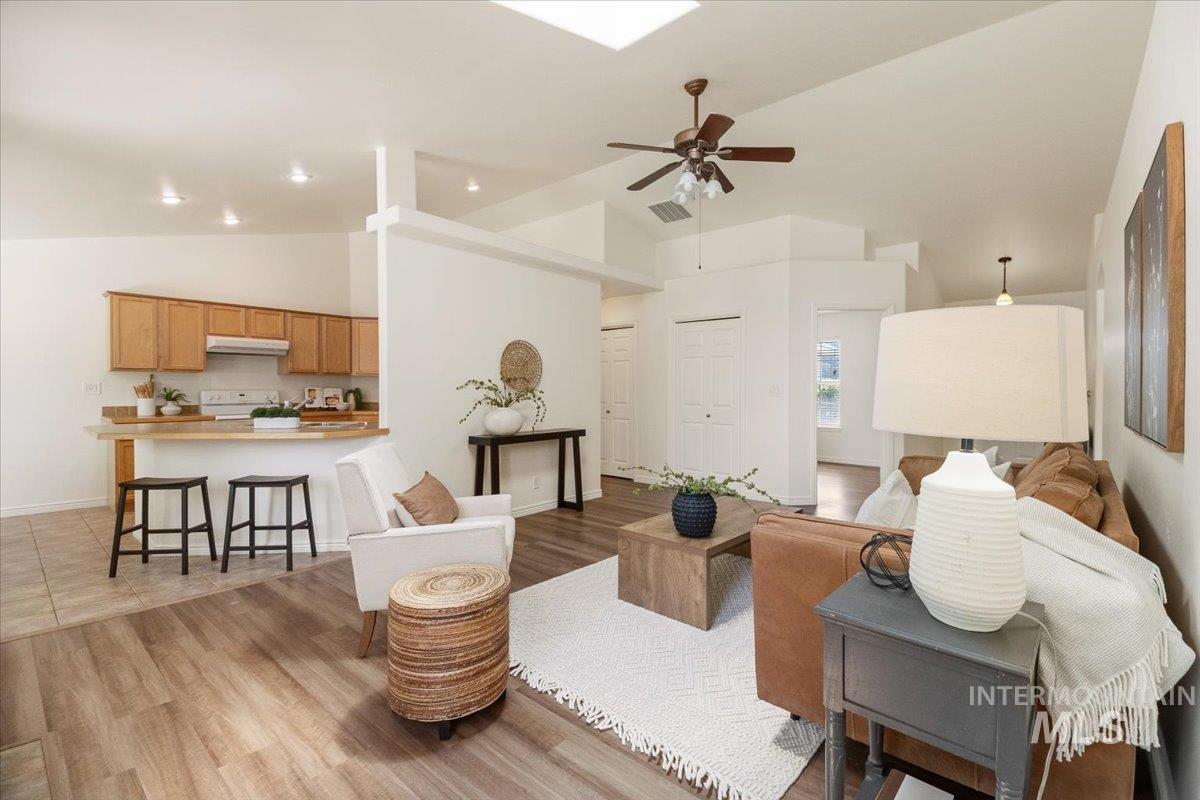 2032 Talus Loop Twin Falls, ID 83301 - Photo 14 of 43 Open-concept living space featuring wood-finish flooring, vaulted ceilings, and a skylight