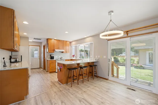 a view of a kitchen with granite countertop a center island attached withe living room