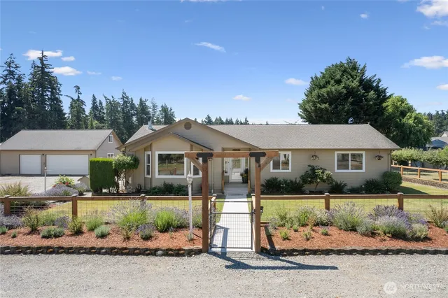 a front view of a house with a yard and potted plants