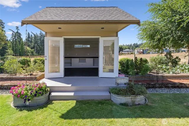 a front view of a house with a yard and potted plants