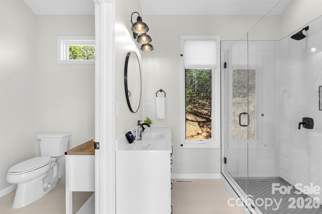 56 Great Horned Owl Road Candler, NC 28715 - Photo 17 of 32 a bathroom with a toilet a sink and shower