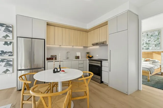 a kitchen with stainless steel appliances a dining table and chairs