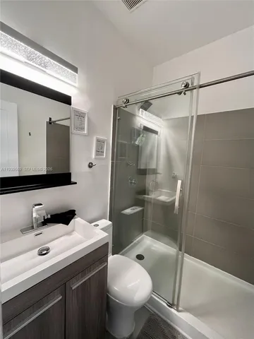 a bathroom with a granite countertop sink toilet and shower