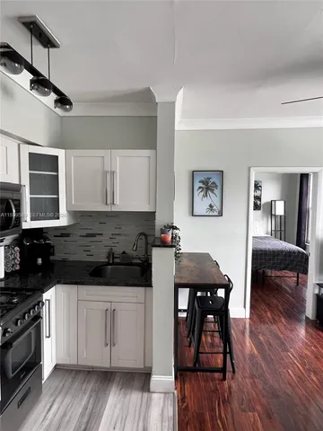 a kitchen with a table chairs refrigerator and cabinets