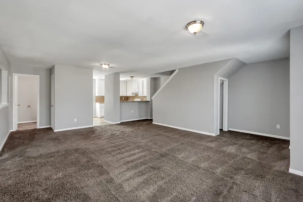 a view of an empty room with a kitchen