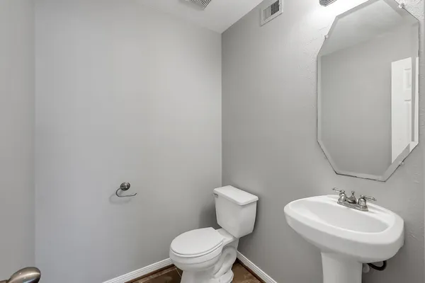 a bathroom with a sink toilet and a mirror
