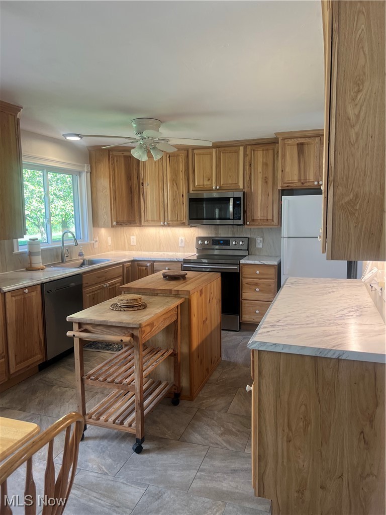 6171 Barrett Road Geneva, OH 44041 - Photo 17 of 38 Kitchen with stainless steel appliances, backsplash, brown cabinets, and wood counters