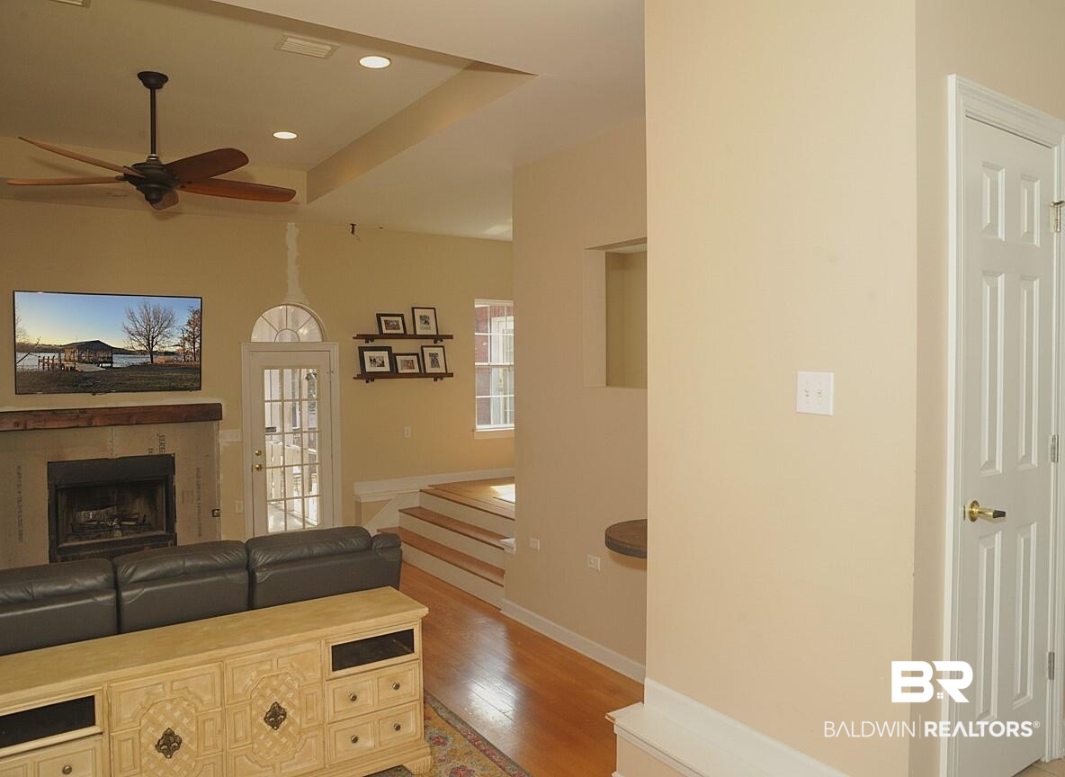 8008 Patricks Landing Road Bay Minette, AL 36507 - Photo 10 of 33 Living area featuring a fireplace with a wood mantle, a ceiling fan, recessed lighting, and a glass-paned door with an arched transom