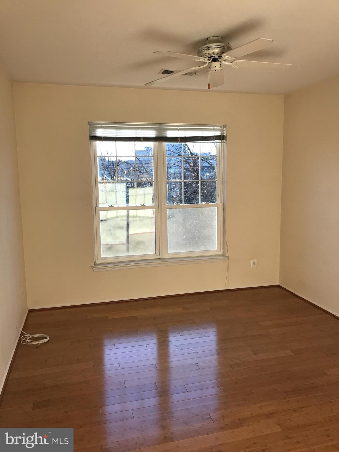 1601 Spring Gate Dr., Unit 1214 McLean, VA 22102 - Photo 15 of 17 a view of an empty room with wooden floor and a window