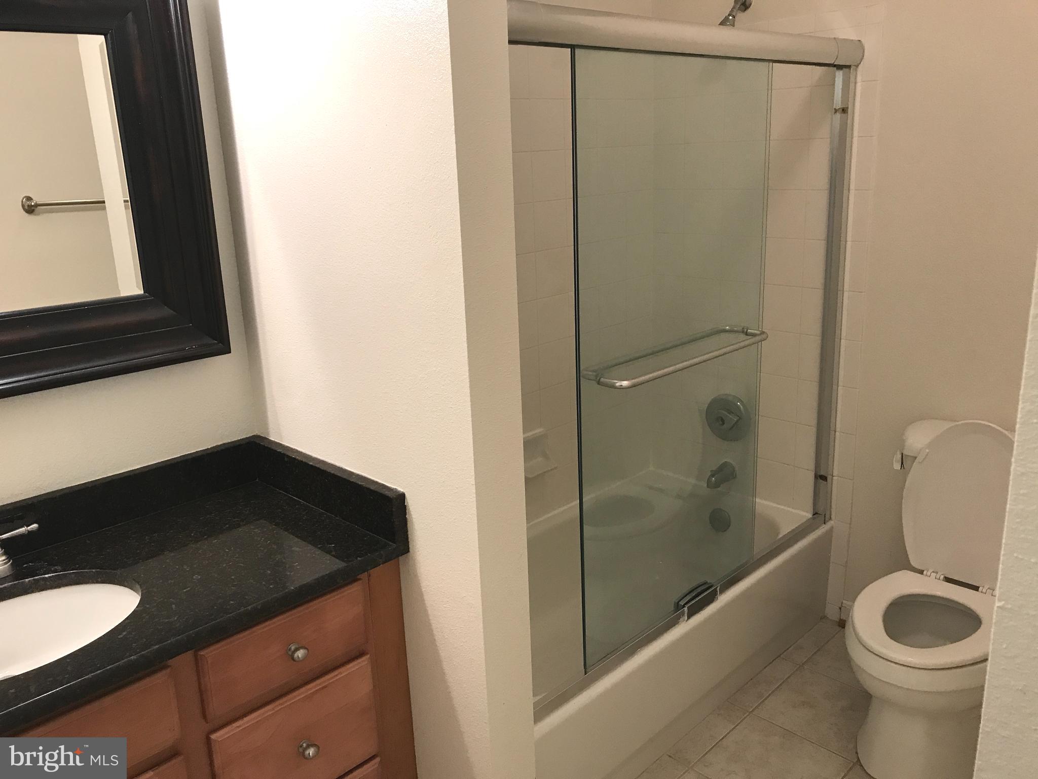 1601 Spring Gate Dr., Unit 1214 McLean, VA 22102 - Photo 16 of 17 a bathroom with a granite countertop sink toilet and shower
