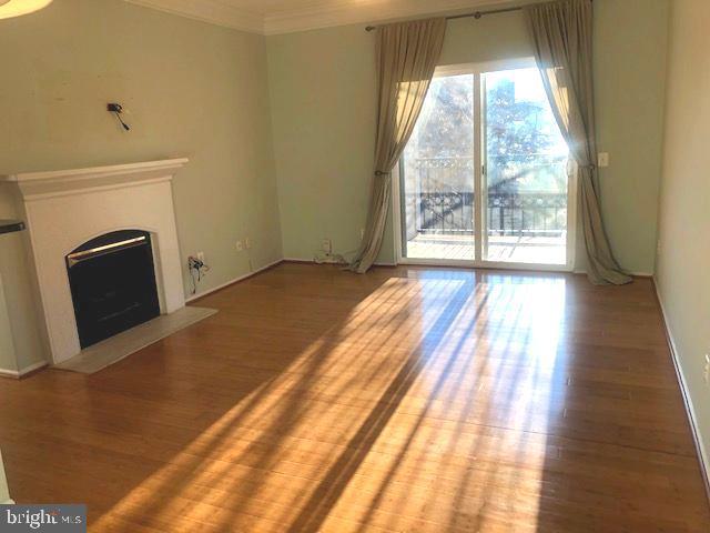 1601 Spring Gate Dr., Unit 1214 McLean, VA 22102 - Photo 3 of 17 a view of a room with wooden floor and a fireplace