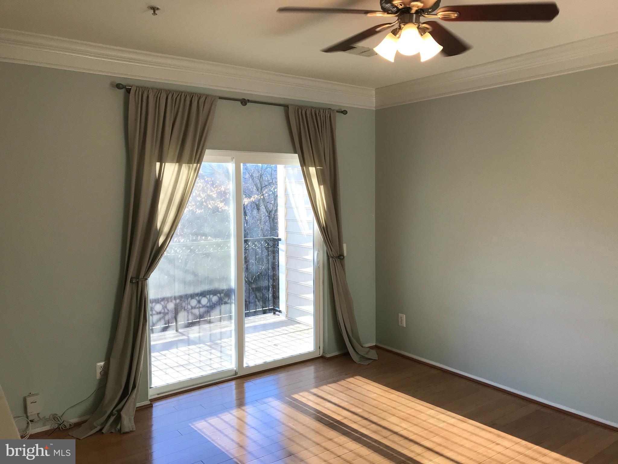 1601 Spring Gate Dr., Unit 1214 McLean, VA 22102 - Photo 4 of 17 an empty room with wooden floor fan and windows