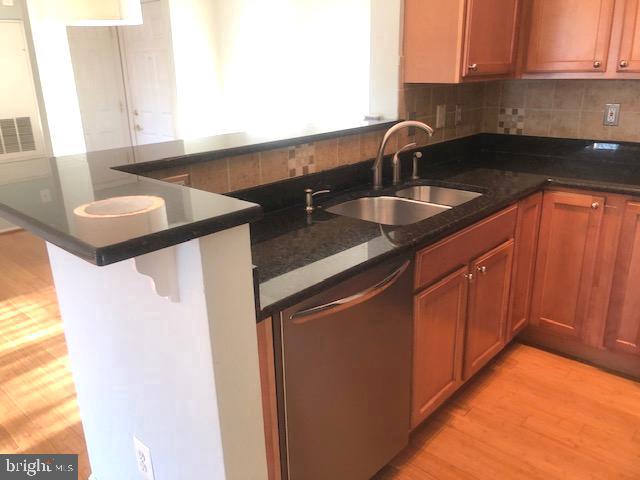 1601 Spring Gate Dr., Unit 1214 McLean, VA 22102 - Photo 7 of 17 a kitchen with stainless steel appliances granite countertop a sink and a white cabinets