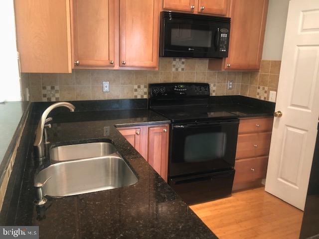1601 Spring Gate Dr., Unit 1214 McLean, VA 22102 - Photo 8 of 17 a kitchen with a sink a microwave and cabinets