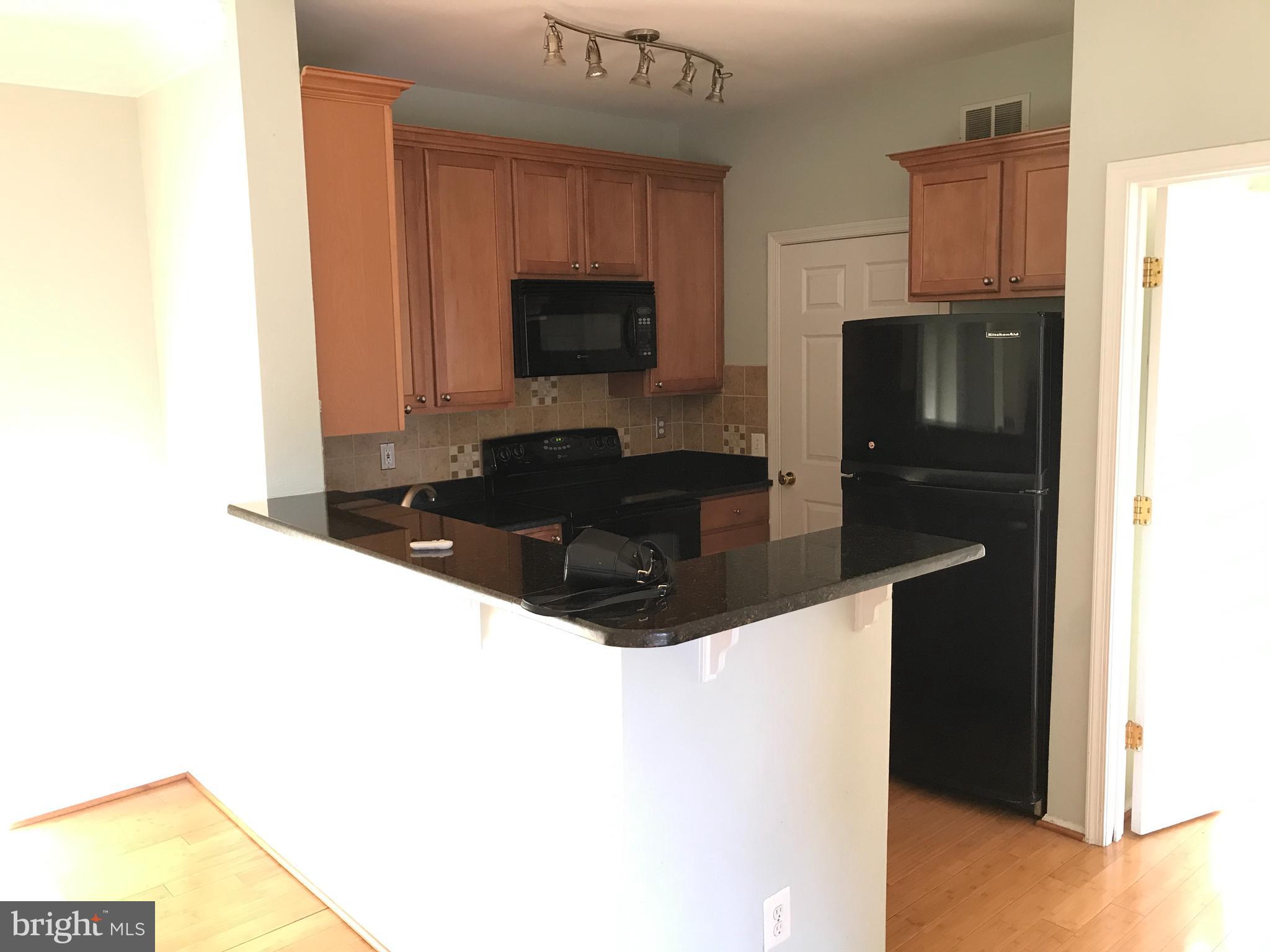 1601 Spring Gate Dr., Unit 1214 McLean, VA 22102 - Photo 10 of 17 a kitchen with granite countertop a refrigerator and a stove