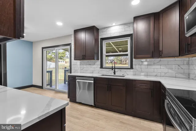 a kitchen with stainless steel appliances granite countertop wooden cabinets a sink and dishwasher