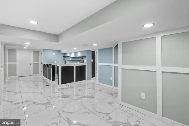 a view of a kitchen with a sink and an empty room