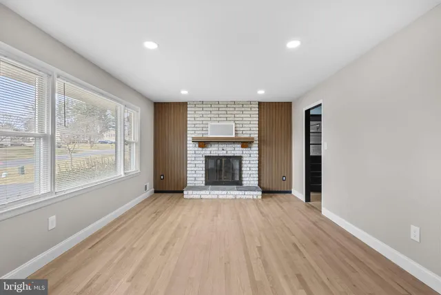 a view of an empty room with a window and fireplace