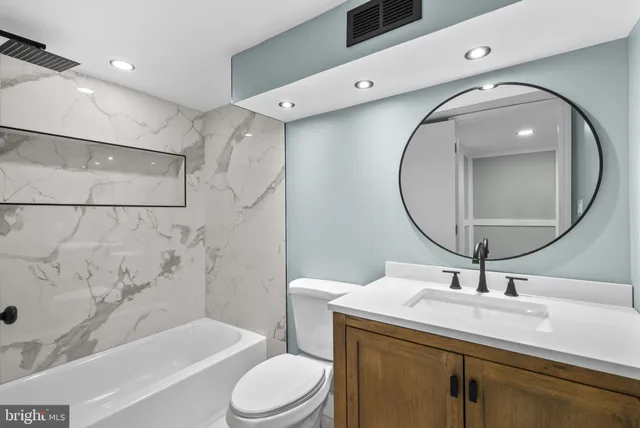 a bathroom with a sink a toilet and a mirror