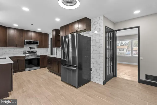a kitchen with kitchen island a counter top space stainless steel appliances and cabinets