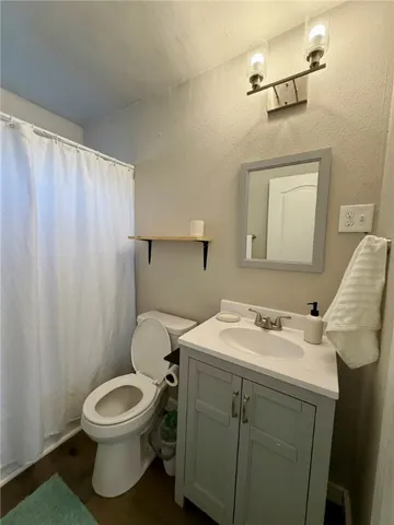 a bathroom with a toilet sink vanity and mirror