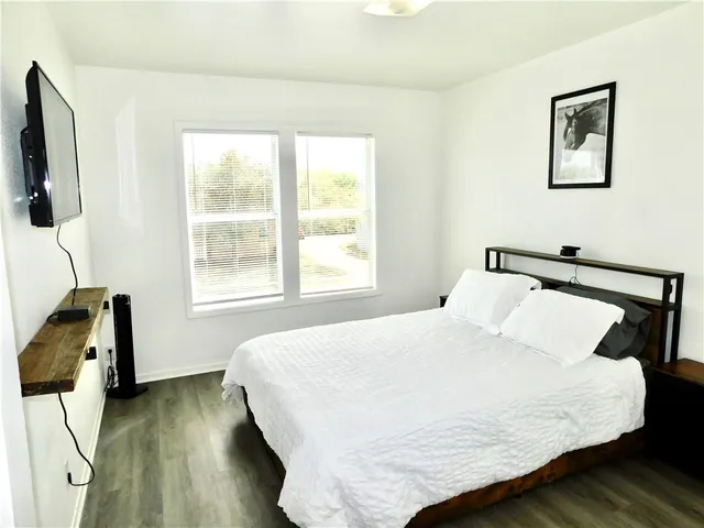 a bedroom with a bed and wooden floor