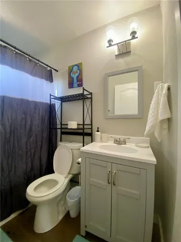 a bathroom with a toilet sink a mirror and vanity