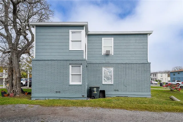 a brick house that has a lots of windows on it