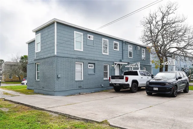 a front view of a house with a garden and parking space