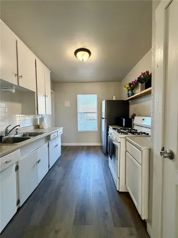 a kitchen with sink stove and refrigerator