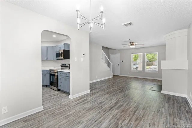 a view of a kitchen with a sink stove cabinets and empty room