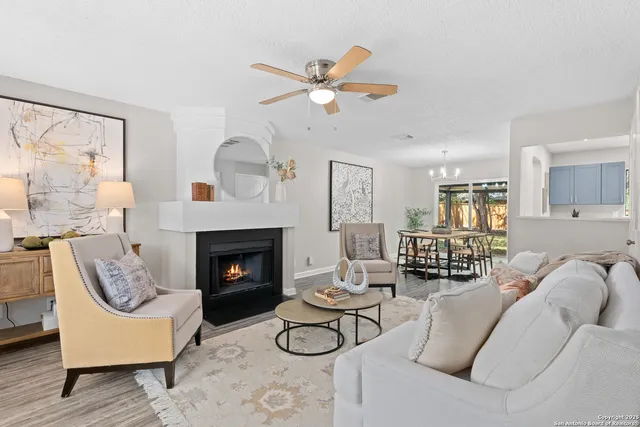 a living room with furniture a fireplace and a large window