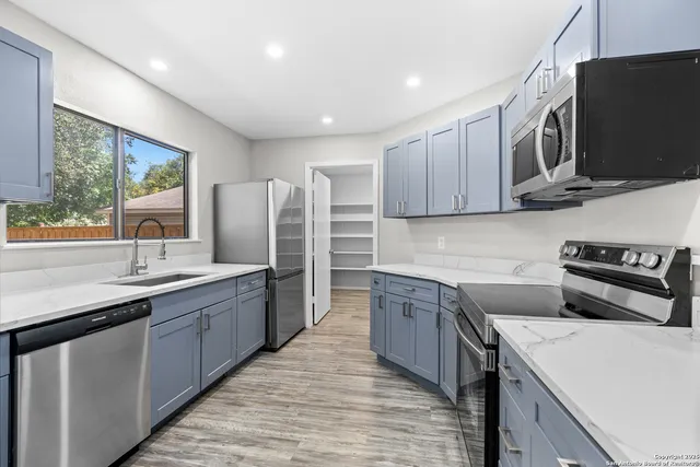 a kitchen with stainless steel appliances granite countertop a sink stove and refrigerator