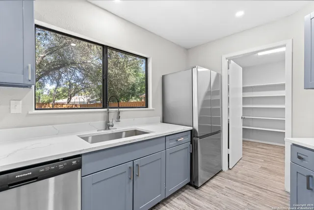 a kitchen with stainless steel appliances granite countertop a refrigerator and a sink
