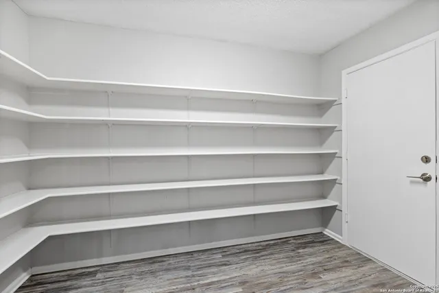 a view of walk in closet with empty racks