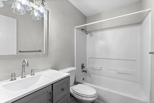 a bathroom with a sink a toilet a mirror and shower