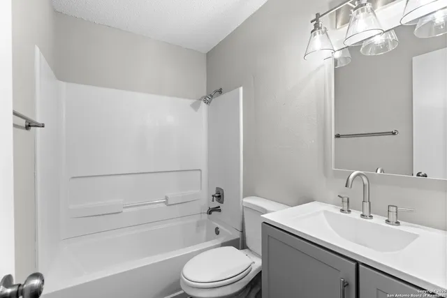 a bathroom with a sink a toilet a mirror and shower