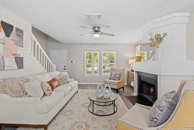 a living room with furniture chandelier and a fireplace