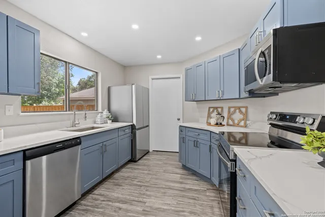 a large kitchen with stainless steel appliances granite countertop a sink and a stove